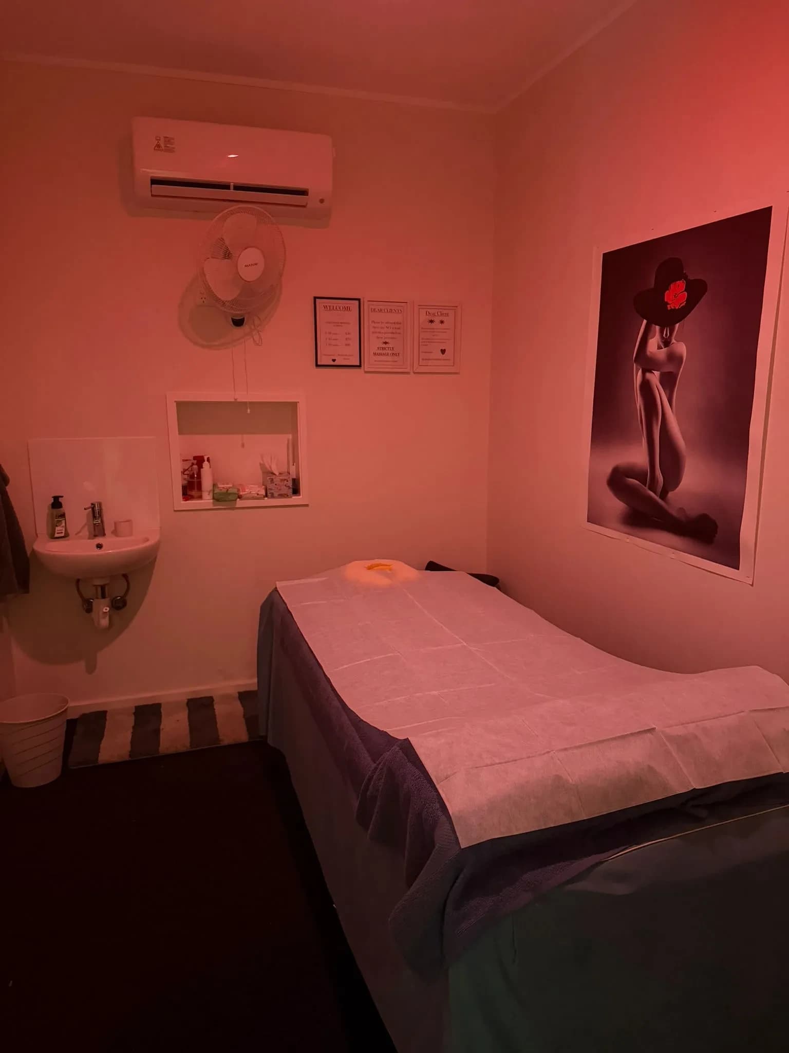 The private treatment room with massage table set up, warm lighting and tranquil decor